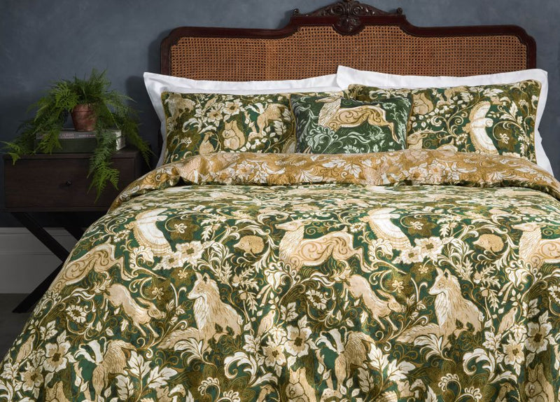 A winter bedroom with navy walls, winter foliage and a yellow duvet cover set with a printed design of winter woodlands and animals.