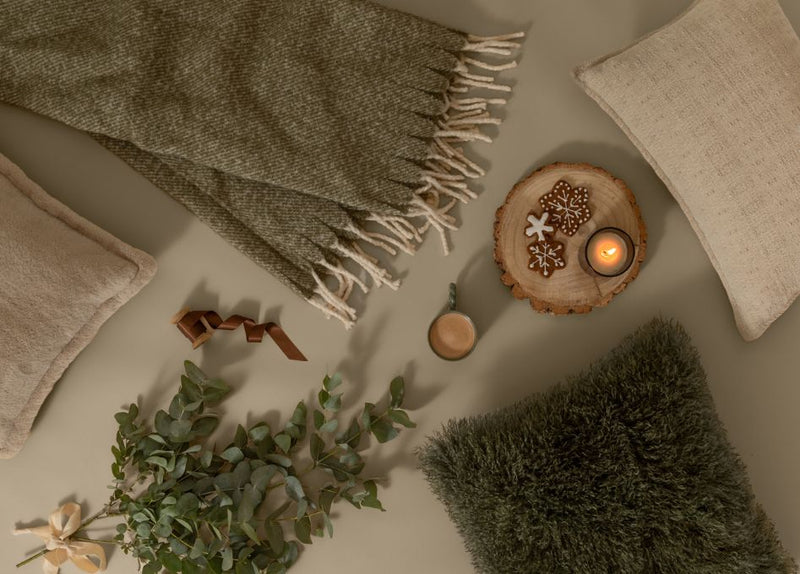 Christmas gifts with a cosy throw, blanket, cushion and a candle all in shades of green