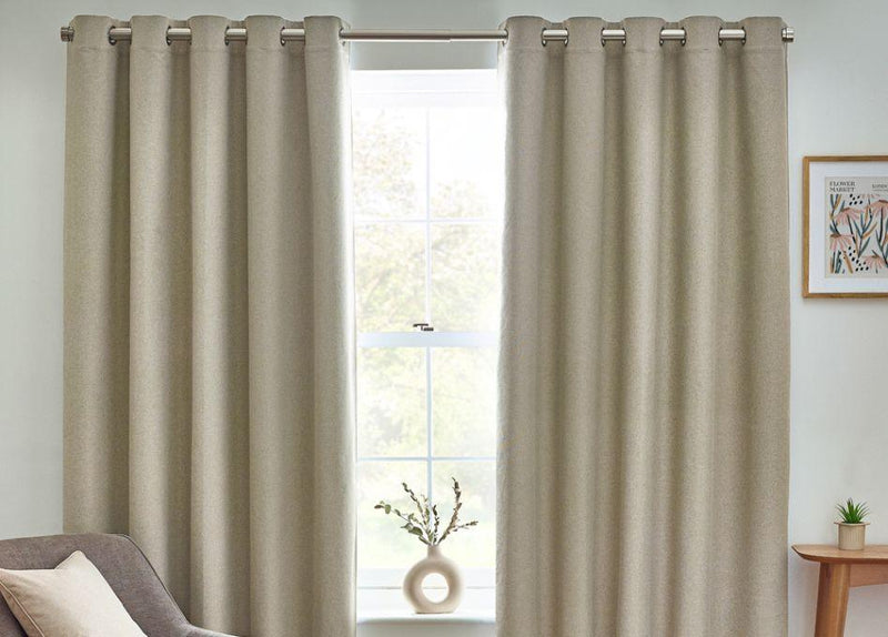 A pair of sage green curtains with a contemporary design of Bengal tigers and jungle foliage, hung in front of an olive green wall in a decorated living room. 