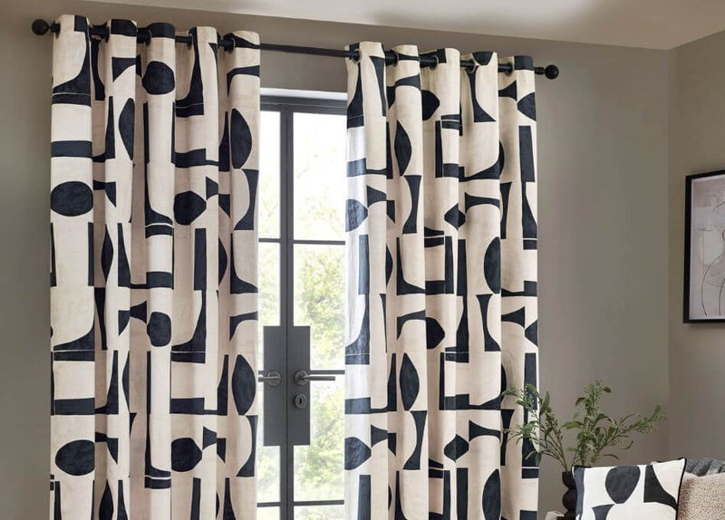 Made to measure eyelet curtains with a monochrome a living room with grey walls and modern decor.