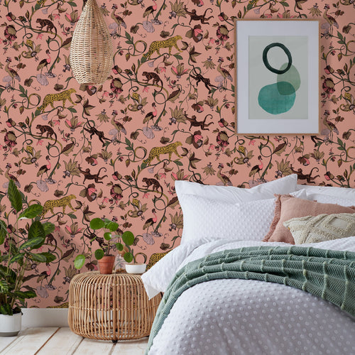 Bedroom wallpaper with an exotic design of jungle animals and florals in a blush pink shade, hung in a modern style bedroom.