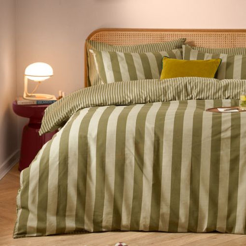 A green striped duvet cover set in two shades of green, with a wide stripe on the front and a reversible smaller stripe on the bak. It has matching striped pillow cases and an ochre colour velvet cushion in the middle.
