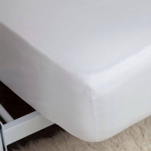A closeup image of the corner of a mattress with a 400 thread count Egyptian cotton white bed sheet pulled over it.