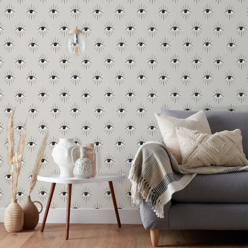 Living room wallpaper with an abstract eye design in sleek black and white shades, hung in a minimalist style space.