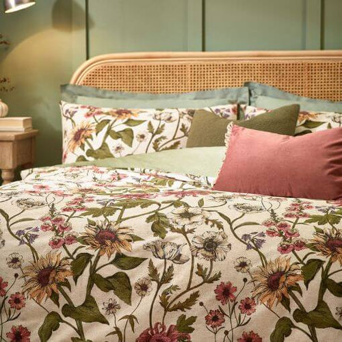 Spring home decor including a floral bedding set with a printed wallflower design and matching pillowcases in an bright bedroom.