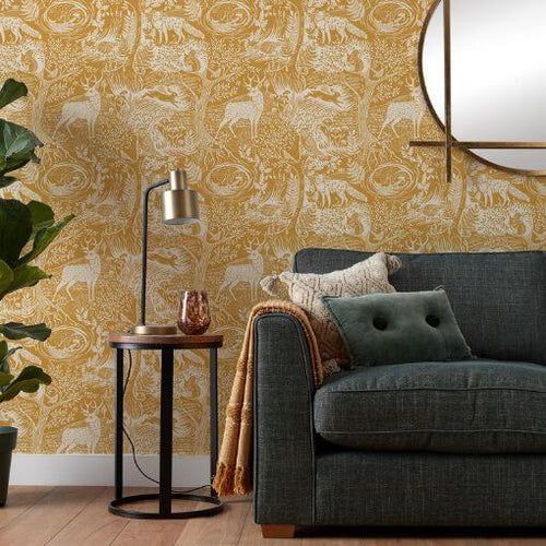 Yellow wallpaper with a printed winter woods design, hung in a stylish living room setting.