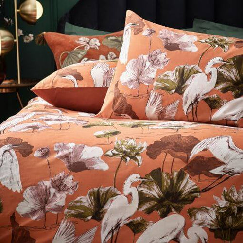 An animal bedding set with a printed design of white cranes among tropical florals in a coral orange hue.n